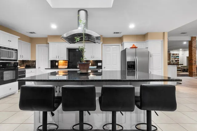 a kitchen with stainless steel appliances granite countertop a sink and a refrigerator