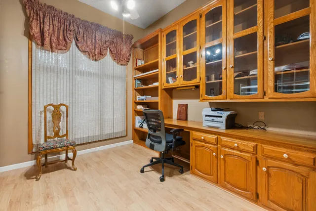 a view of a workspace with furniture and a window