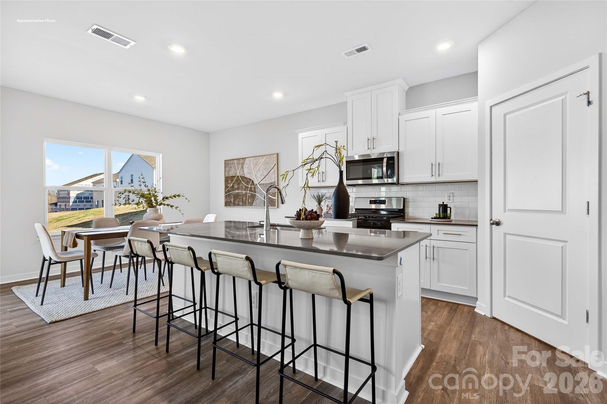 1375 Mammoth Road Hickory, NC 28602 - Photo 6 of 20 a kitchen with stainless steel appliances granite countertop a stove a sink a microwave a dining table and chairs with wooden floor