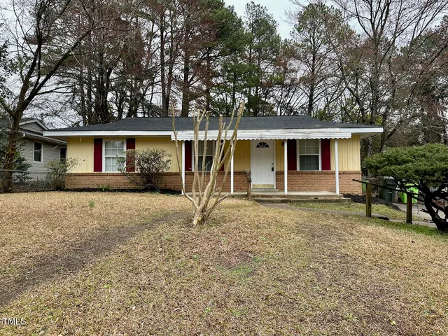 a view of a house with a yard and large tree