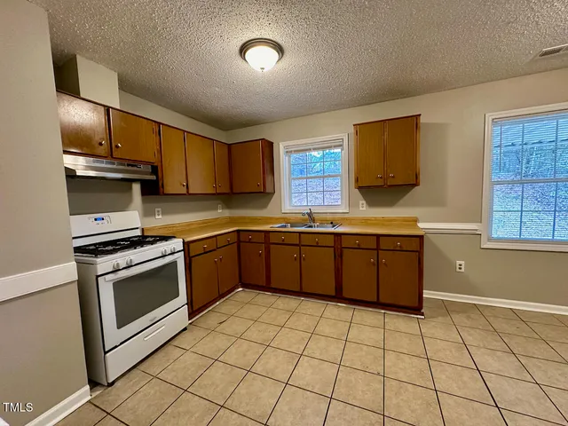 a kitchen with stainless steel appliances granite countertop a sink counter space cabinets and a stove top oven