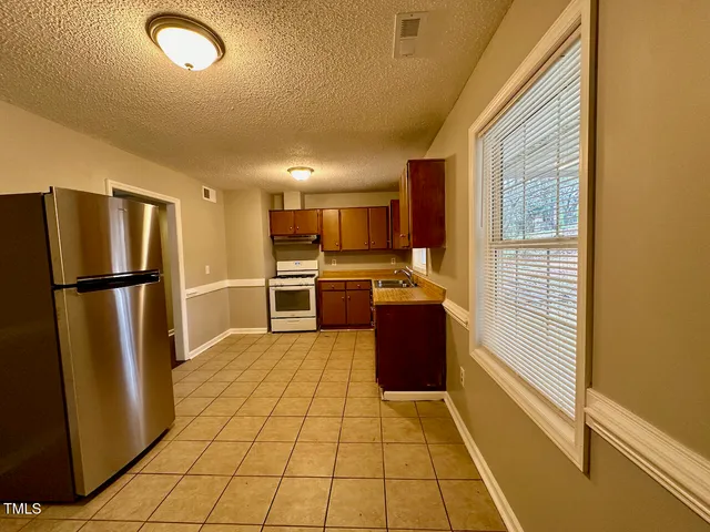 a kitchen with stainless steel appliances granite countertop a refrigerator and a stove