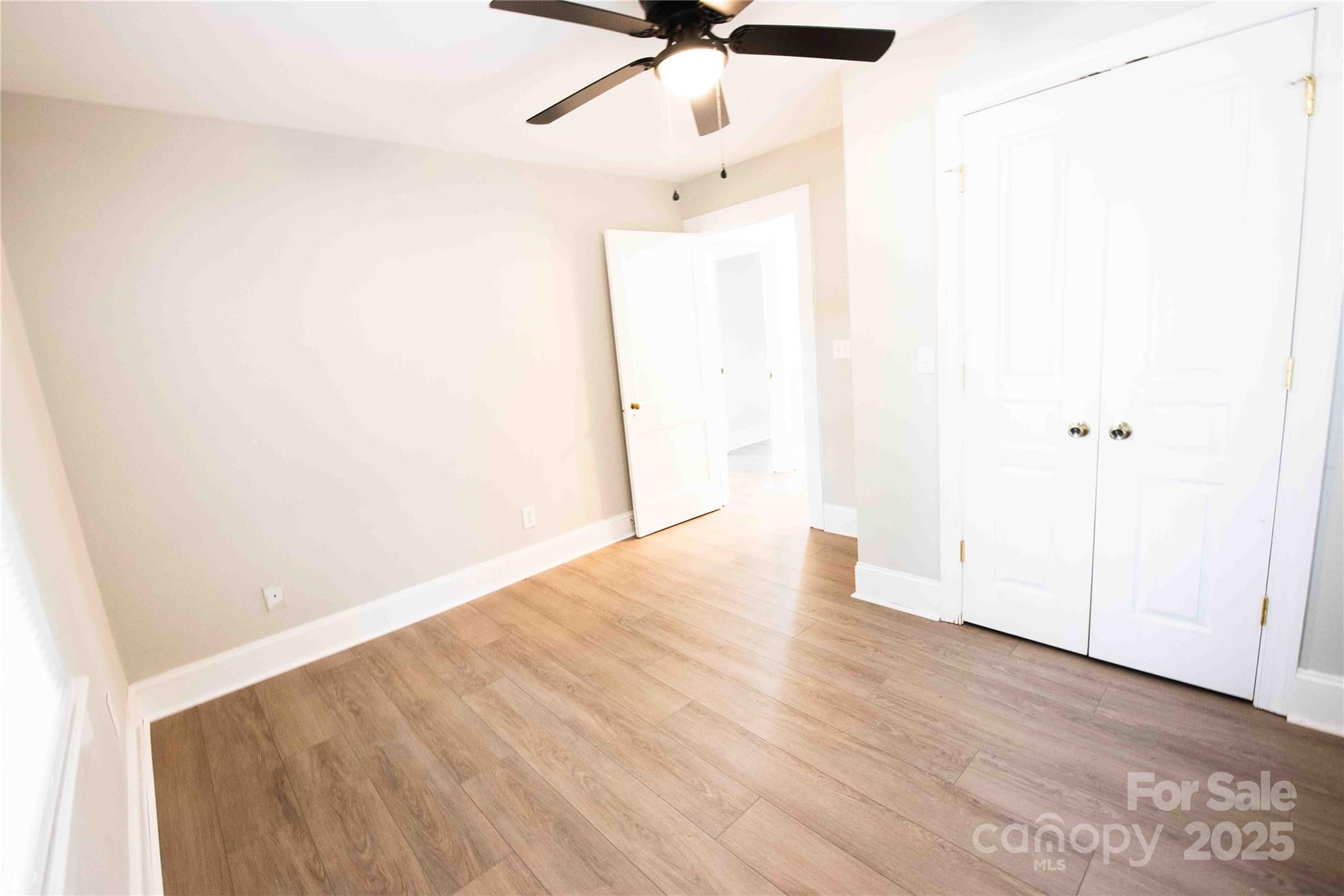 207 North Love Chapel Road Stanfield, NC 28163 - Photo 18 of 21 an empty room with wooden floor fan and windows