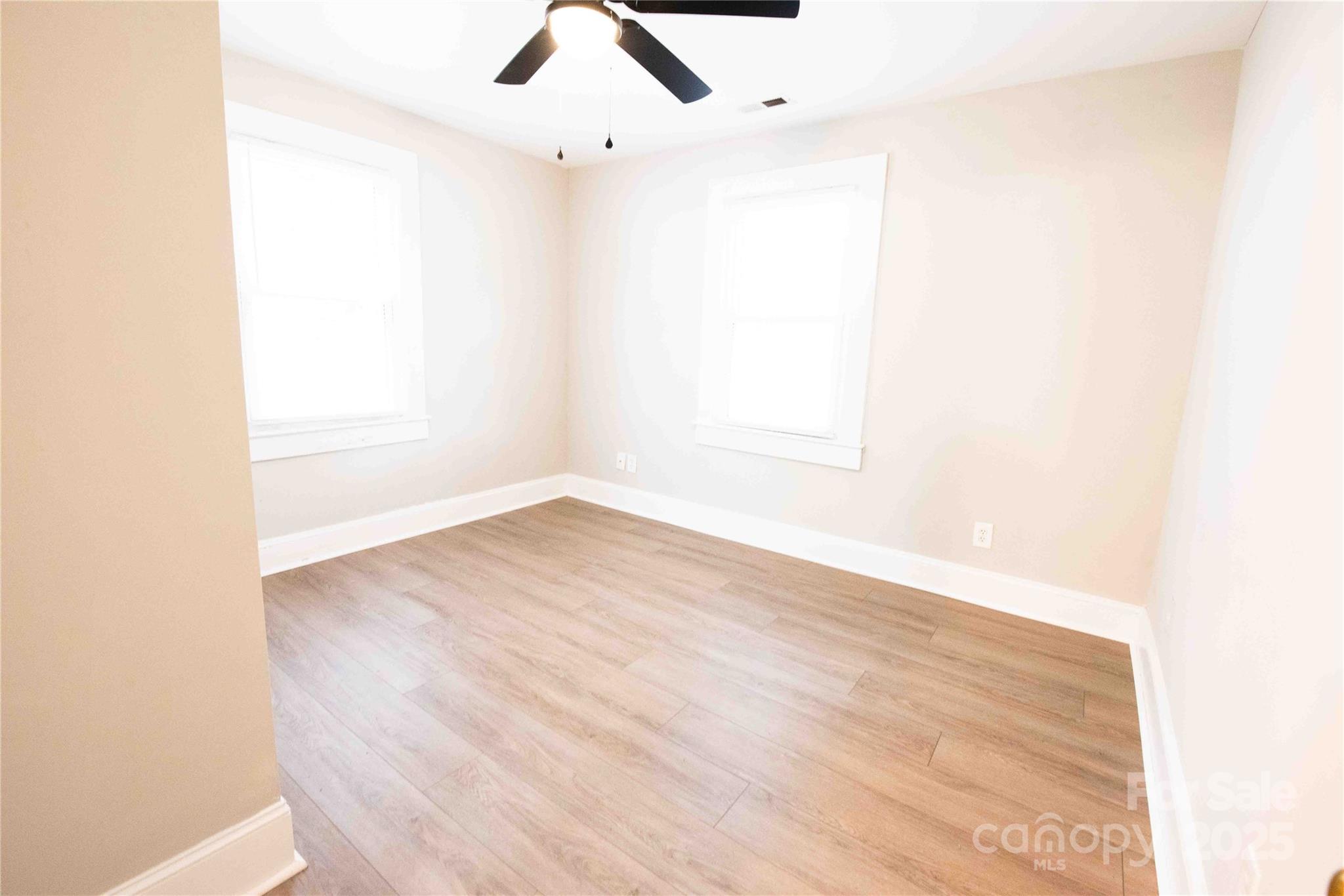 207 North Love Chapel Road Stanfield, NC 28163 - Photo 19 of 21 an empty room with wooden floor and windows