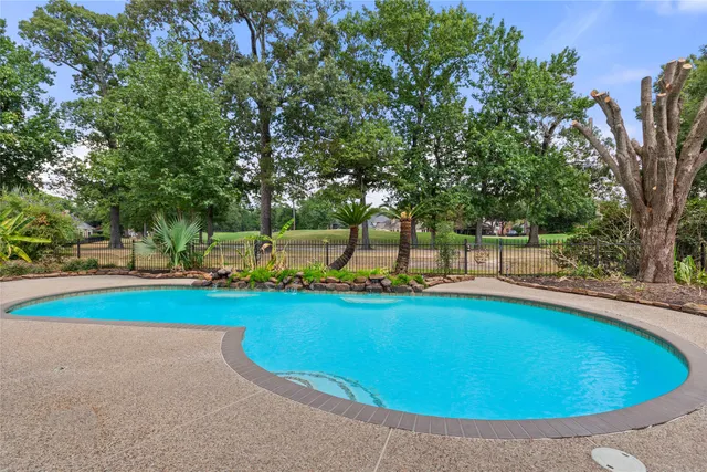 a view of a swimming pool and trees in the background