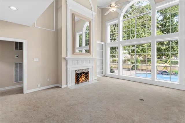 a view of an empty room with a fireplace and a window