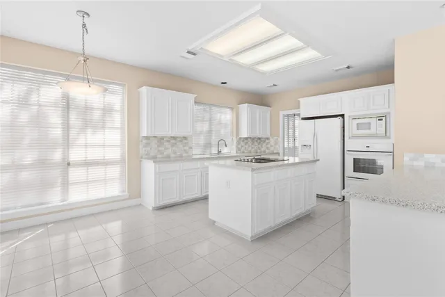 a kitchen with white cabinets and white appliances