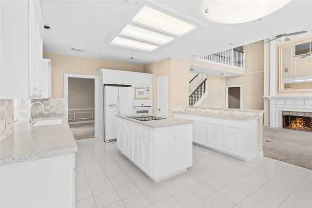a kitchen with granite countertop a sink and white cabinets