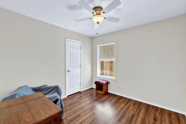 a view of a room with wooden floor and a ceiling fan