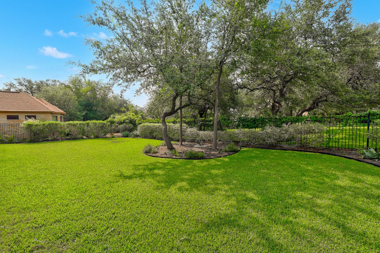 809 Prairie Dunes Drive Georgetown, TX 78628 - Photo 38 of 40 A verdant backyard offers ample space for recreation, bordered by mature trees and manicured hedges.