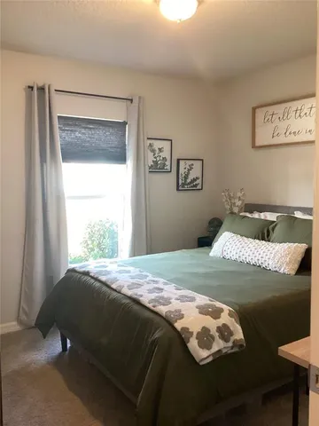 a kitchen with white cabinets and a window