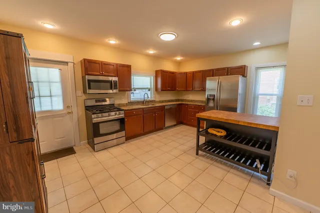 a kitchen with stainless steel appliances a refrigerator and a stove top oven