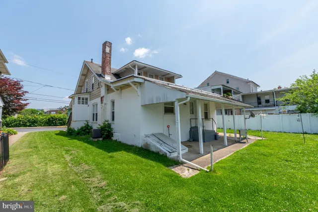 a view of a house with a yard and sitting area