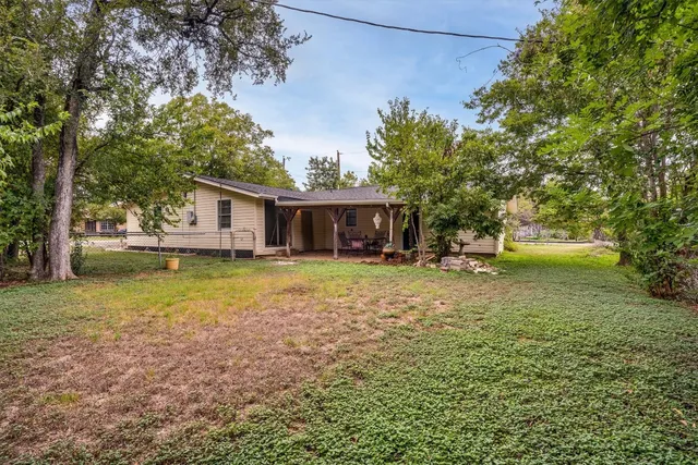 a view of a house with backyard and tree