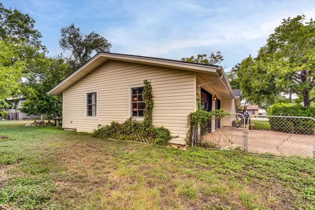 a backyard of a house with table and chairs