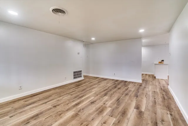 a view of empty room with wooden floor