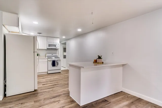 a kitchen with stainless steel appliances a white stove top oven a sink and a refrigerator