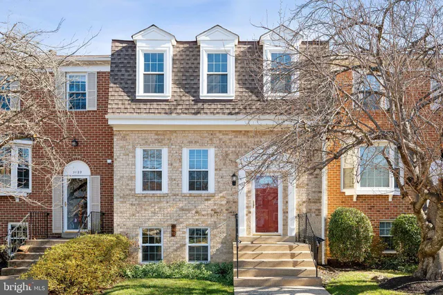 front view of a brick house with a yard