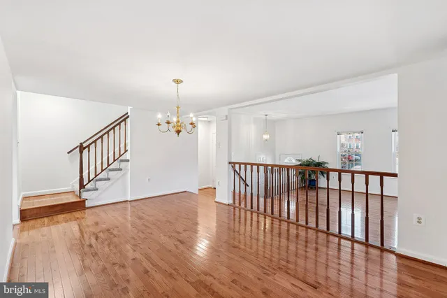 a view of a hallway with wooden floor and stairs