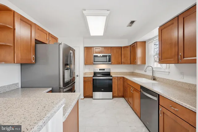 a kitchen with stainless steel appliances granite countertop a refrigerator stove a sink and dishwasher