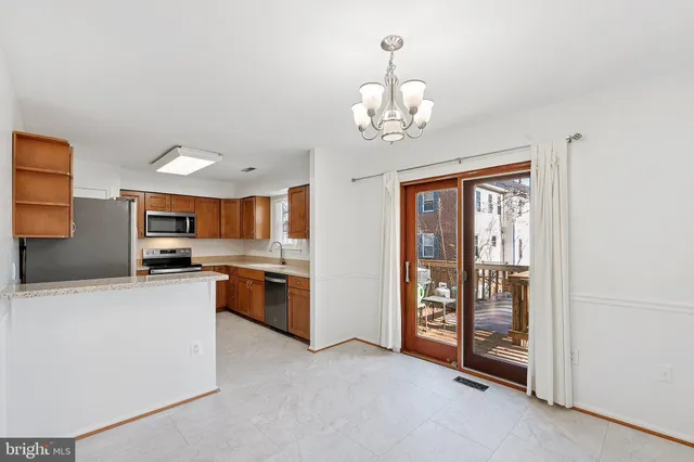 a view of a kitchen with stainless steel appliances granite countertop a refrigerator and a stove top oven