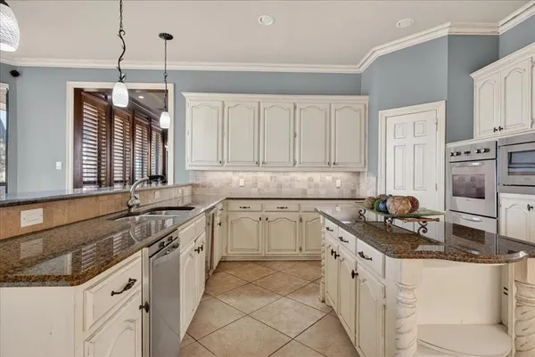 a kitchen with granite countertop a sink a stove and cabinets