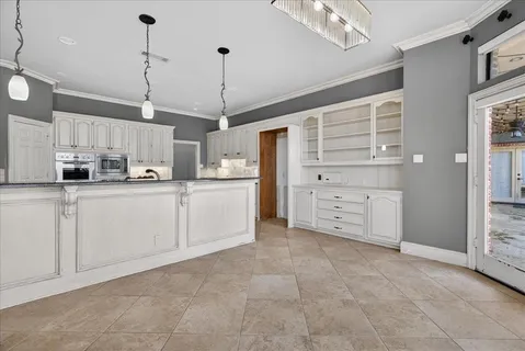 a view of an empty room with wooden floor fireplace and a window