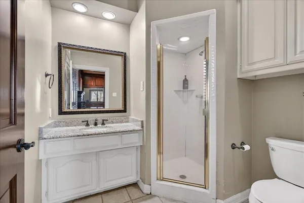 a bathroom with a toilet sink vanity and mirror