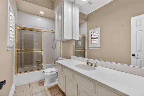 a bathroom with a granite countertop toilet sink and mirror
