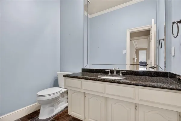 a bathroom with a granite countertop toilet sink and mirror
