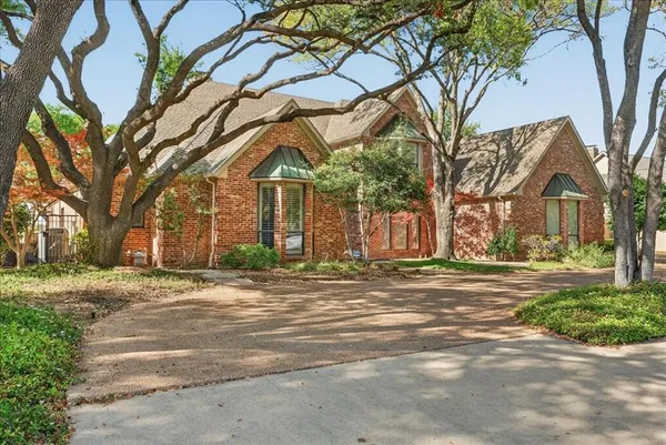 a view of a trees in front of a brick house