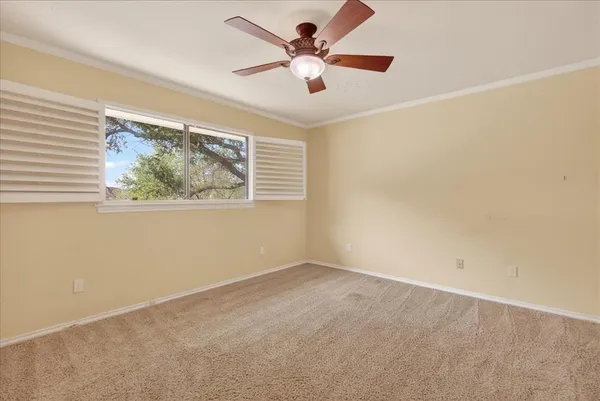 an empty room with windows and fan