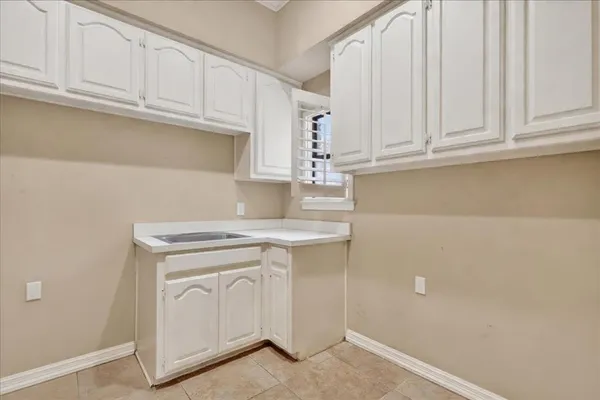 a kitchen with white cabinets and a sink
