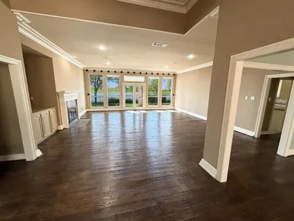 an empty room with wooden floor and a fireplace