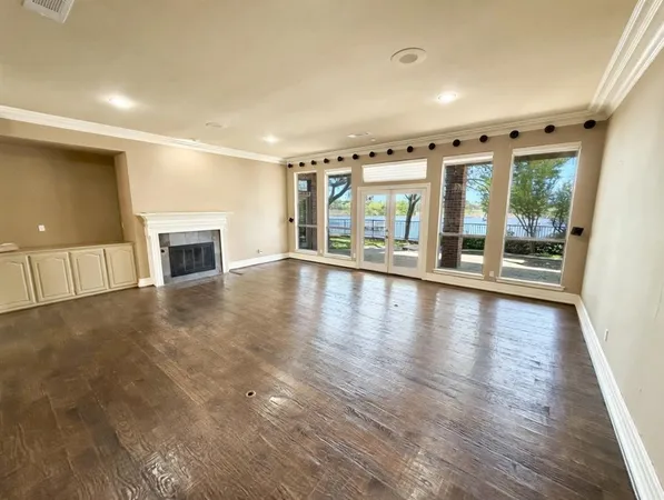 an empty room with wooden floor and a fireplace