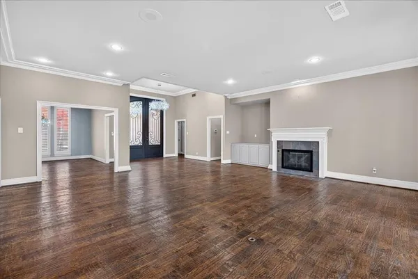 an empty room with wooden floor and fireplace