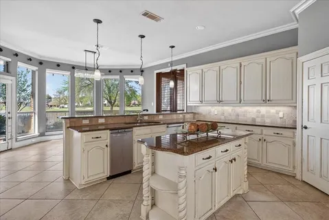 a kitchen with granite countertop a sink stove and cabinets