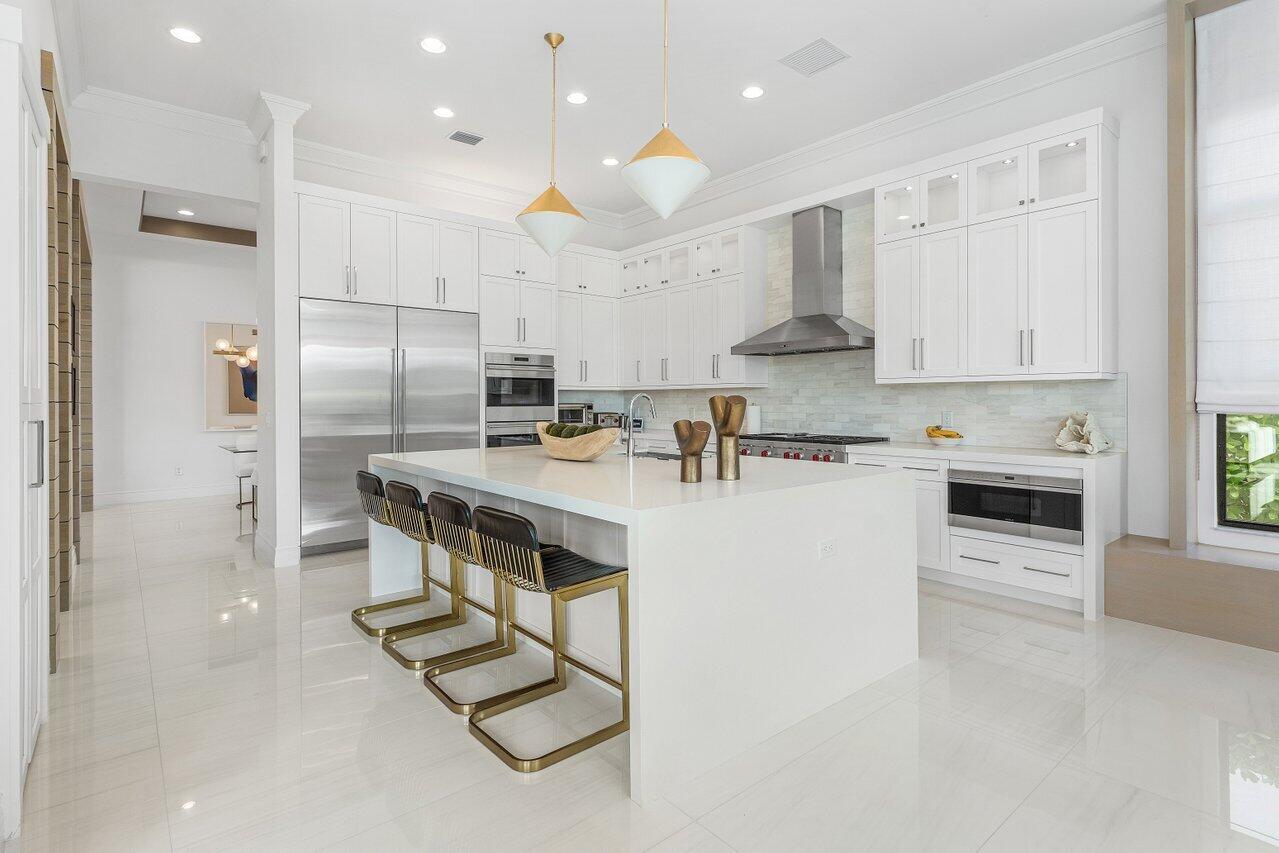 9276 Biaggio Road Boca Raton, FL 33496 - Photo 19 of 70 a kitchen with stainless steel appliances kitchen island granite countertop a stove a refrigerator and a sink