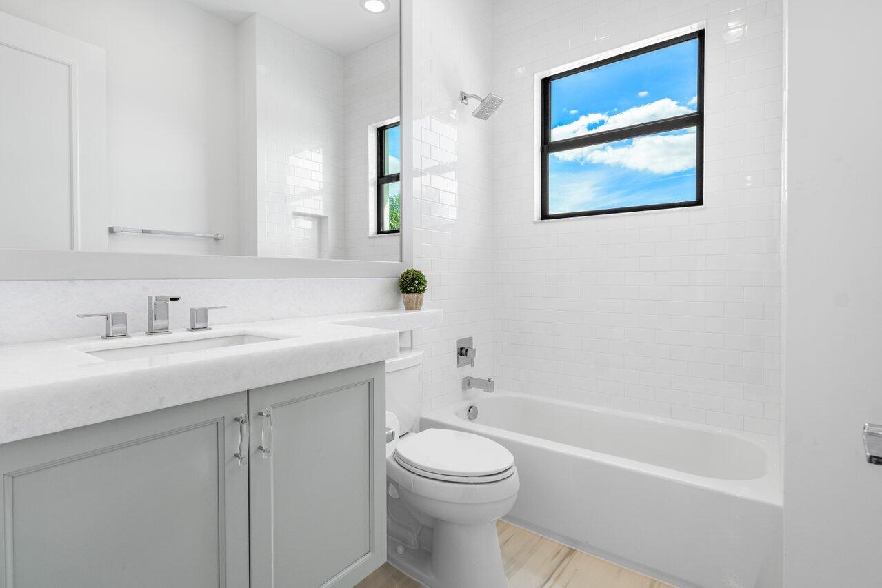 9276 Biaggio Road Boca Raton, FL 33496 - Photo 32 of 70 a bathroom with a toilet a sink a mirror and a bathtub