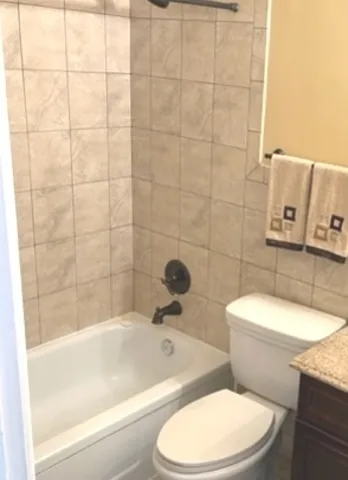 a white toilet and tub sitting next to a bathroom sink