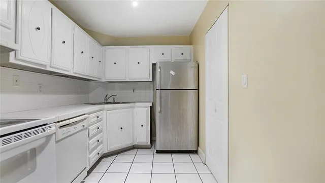a kitchen with white cabinets and white appliances