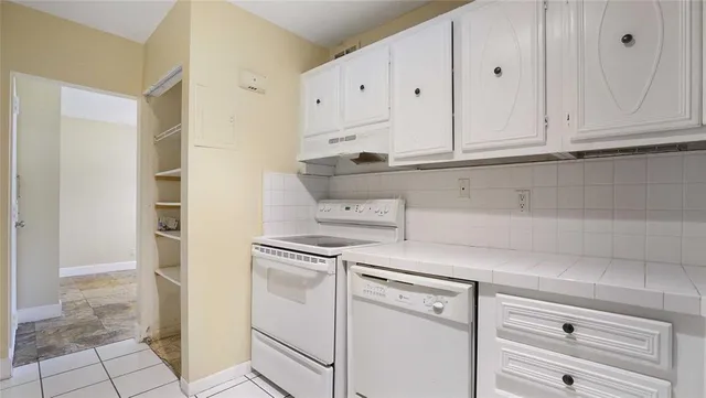 a kitchen with white cabinets and white appliances