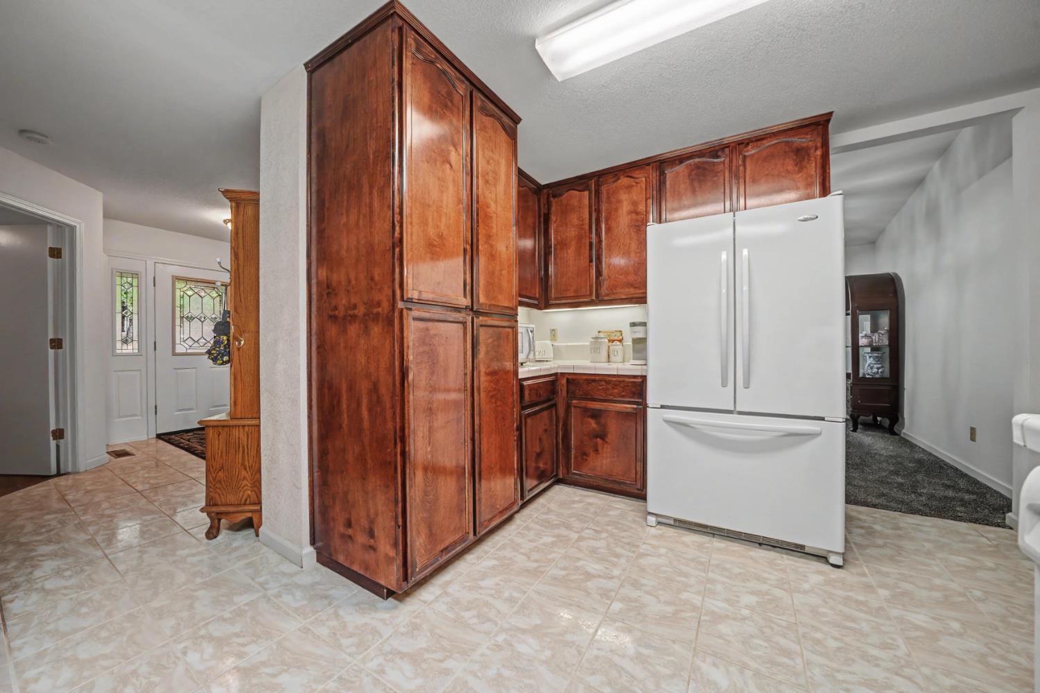 27390 Barton Road Pioneer, CA 95666 - Photo 22 of 52 a view of kitchen with refrigerator and white cabinets