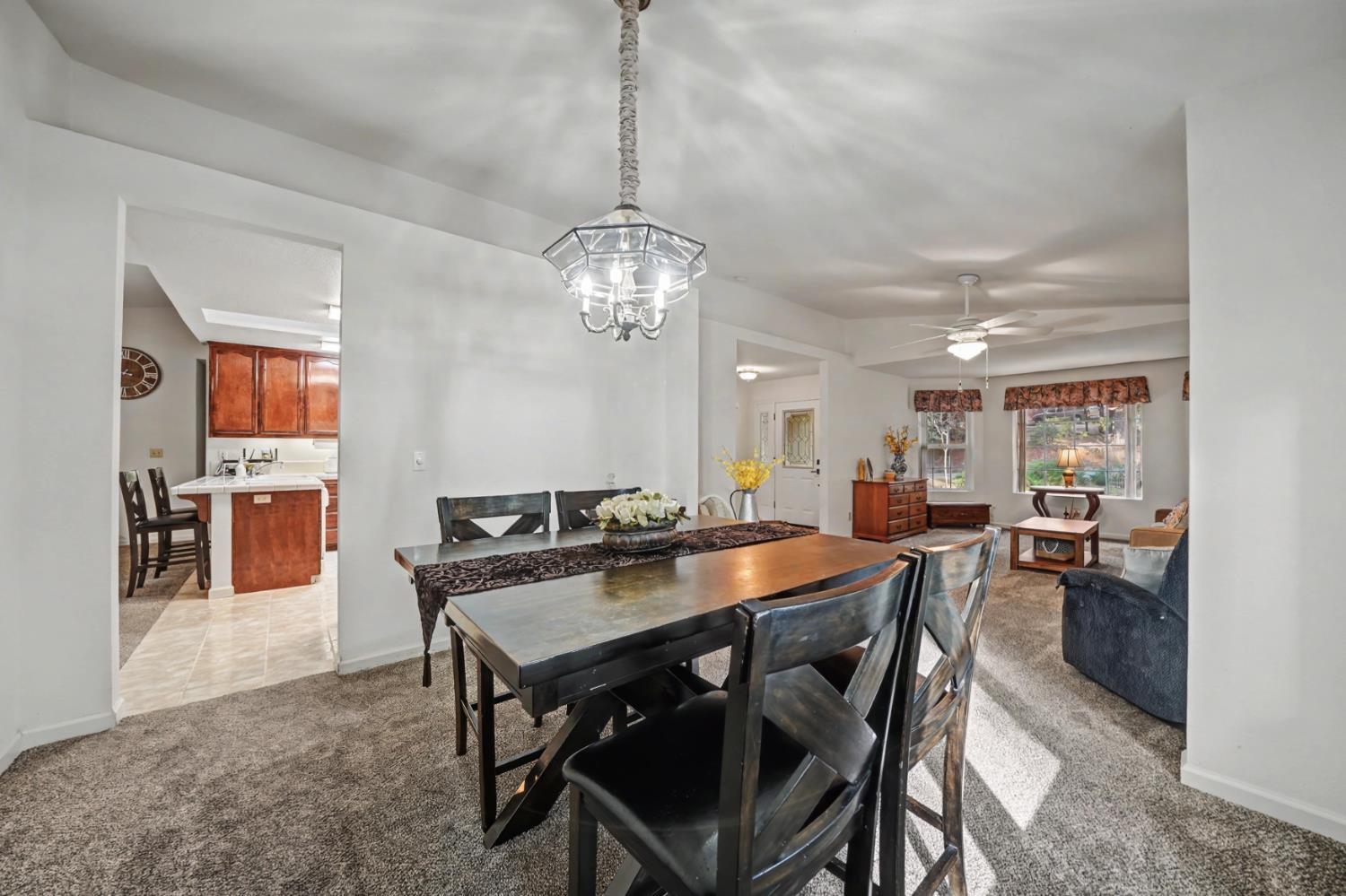 27390 Barton Road Pioneer, CA 95666 - Photo 26 of 52 a view of a dining room and livingroom with furniture wooden floor a chandelier