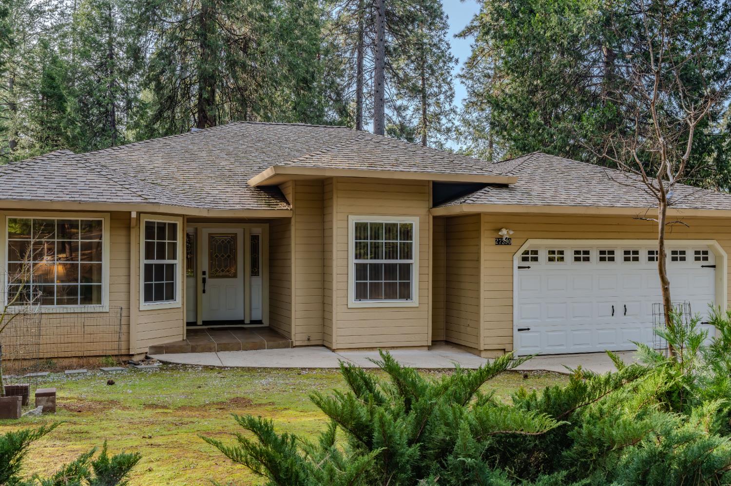27390 Barton Road Pioneer, CA 95666 - Photo 7 of 52 a view of a white house with large windows and a small yard