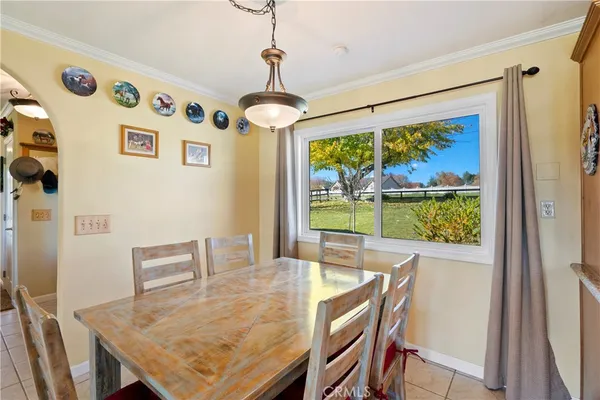a kitchen with stainless steel appliances granite countertop a stove top oven a refrigerator a sink and a dining table with wooden floor