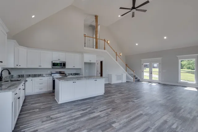 a kitchen with granite countertop a sink a stove and cabinets