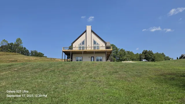 a house with green field in front of it