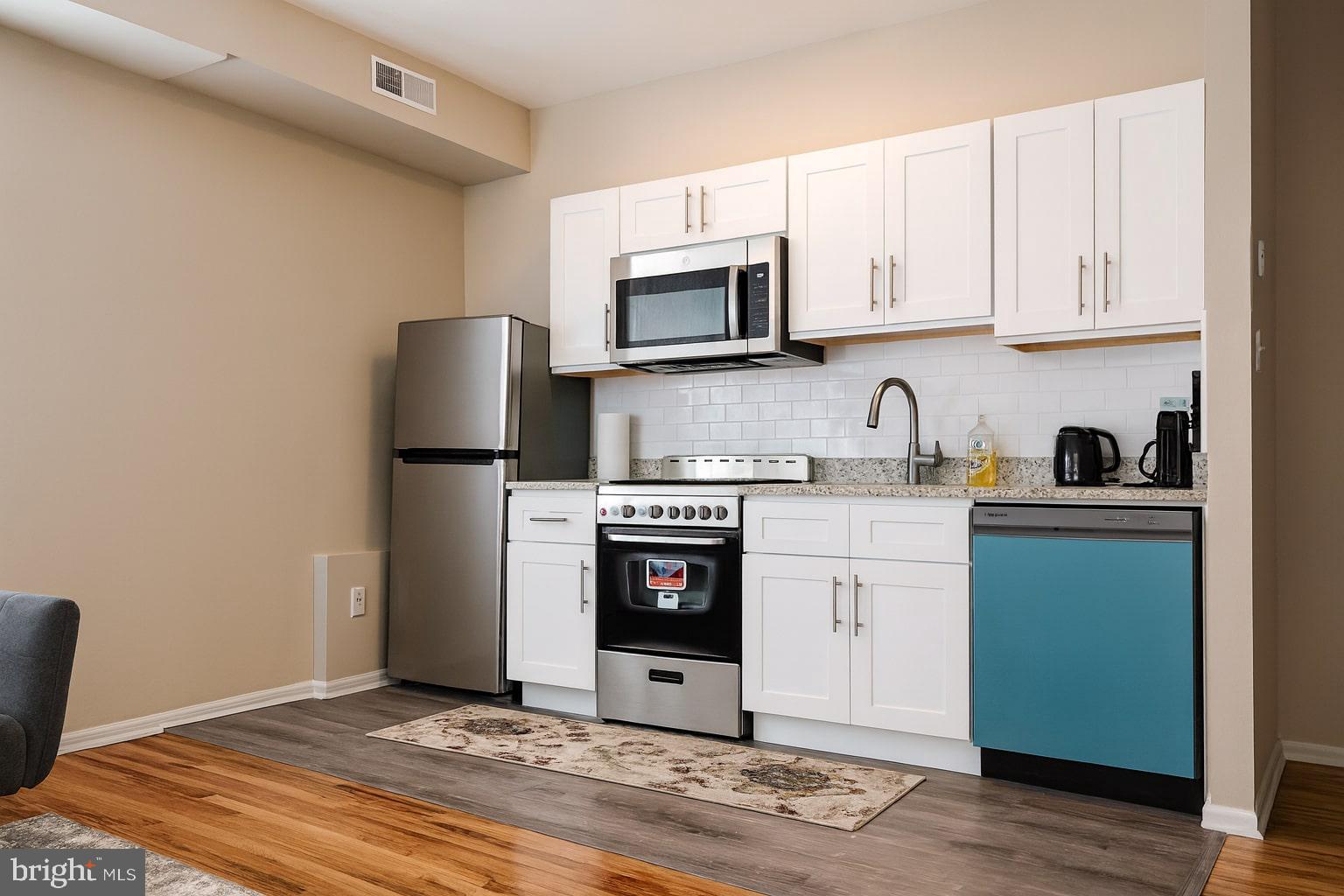 1214 Waverly Street, Unit 303 Philadelphia, PA 19147 - Photo 2 of 15 a kitchen with stainless steel appliances granite countertop a refrigerator stove and microwave