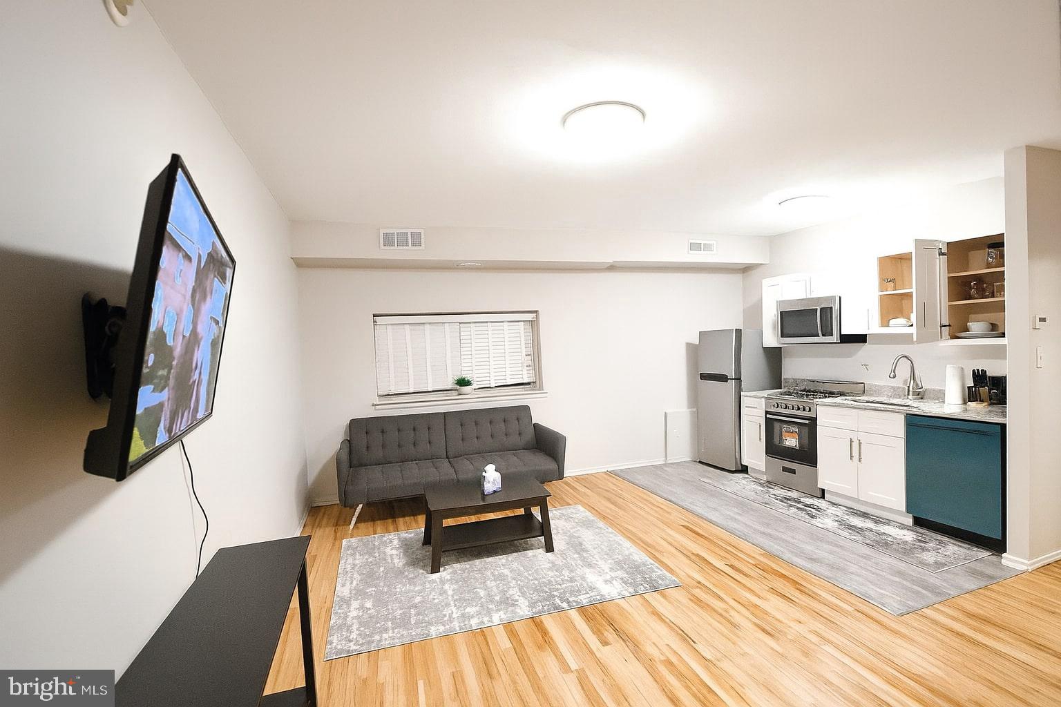 1214 Waverly Street, Unit 303 Philadelphia, PA 19147 - Photo 5 of 15 a living room with furniture and a flat screen tv